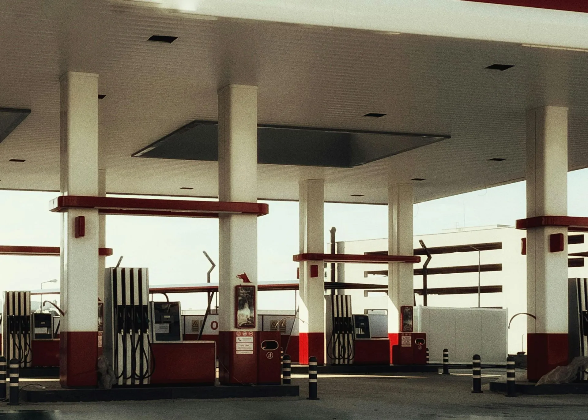 Gas station canopy over fuel pump islands on a concrete forecourt